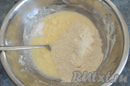 Затем начать в миску частями всыпать муку, каждый раз полностью вмешивая её в тесто.