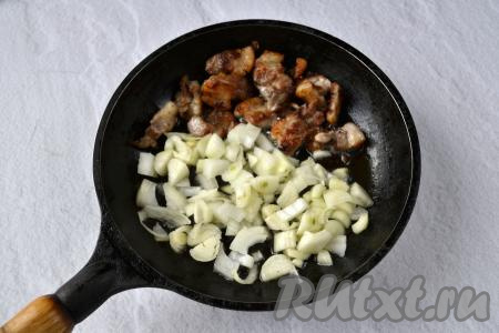 Получившиеся шкварки сдвиньте на половину сковороды, на освободившееся место выложите нарезанный лук.