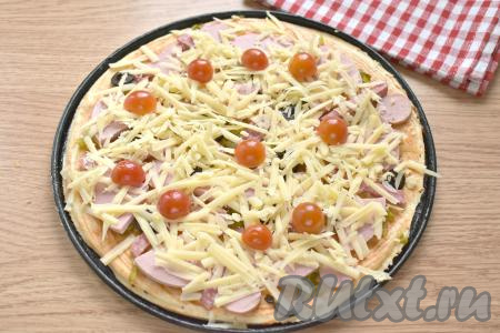 Сыр натираем на крупной тёрке. Сверху начинку присыпаем половиной натёртого сыра, выкладываем 4-5 разрезанных пополам помидоров черри (или 1 помидор среднего размера, нарезанный на кружочки). Аналогично формируем вторую пиццу с солёными огурцами, колбасой и сыром.