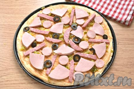 Для начинки можно взять один или несколько видов колбасы. Я взяла 80 грамм варёной колбасы, 70 грамм копчёной колбасы и 2 сосиски. Нарезаем колбасу (у меня - колбаса и сосиски) на средние кусочки любой формы. Маслины, если будете использовать, нарезаем на кружочки. Поверх основы для первой пиццы выкладываем половину нарезанных колбасы и маслин.