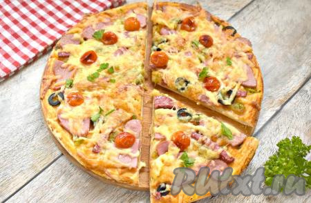 Пицца с солёными огурцами, колбасой и сыром получилась вкусной, аппетитной и сытной. Пока она горячая, разрезаем её на кусочки и сразу угощаемся.