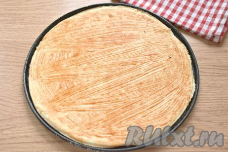 В рецепте количество ингредиентов дано для двух пицц диаметром около 25 сантиметров. Делим поднявшееся тесто на 2 части. Одну часть теста на присыпанном мукой столе раскатываем в круг диаметром 25 сантиметров и перекладываем на противень, смазанный маслом (или застеленный пергаментом). Поскольку у нас будет 2 пиццы, соответственно ингредиенты для начинки также делим на 2 части. Смазываем основание для пиццы томатным соусом (или кетчупом).