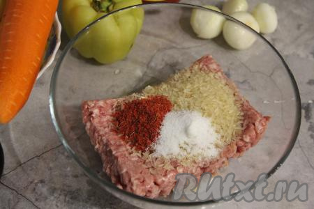 Лук и морковь почистить. Для формирования тефтелей можно приготовить фарш в домашних условиях, пропустив кусочки мяса через мясорубку. В этот раз я решила использовать покупной фарш из свинины. Переложить фарш в миску, добавить к нему сухой рис, соль и специи (у меня - паприка), тщательно вымесить фарш.