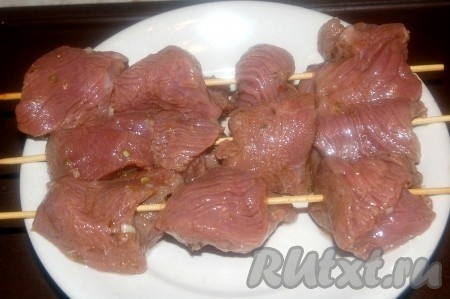 Спустя время, достать миску с маринованным мясом из холодильника, приготовить деревянные шпажки и на них нанизать кусочки говядины.
