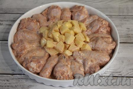 В форму для запекания (я взяла круглую керамическую форму диаметром 30 сантиметров) выложить по периметру (я выложила по кругу) крылышки. В середину формы выложить картошку.&nbsp;