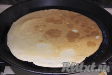 Выпекать блин с двух сторон до золотистости. А затем переложить тонкий блинчик на тарелку.