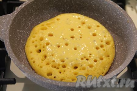 Сковороду (я готовила на сковороде диаметром 18 сантиметров) хорошо разогреть. Я выпекала блины на сухой сковороде, растительным маслом её не смазывала, но важно ориентироваться на качество покрытия сковороды, на которой вы готовите, поэтому если во время выпечки блины пристают, тогда обязательно смажьте сковороду немного маслом. На хорошо разогревшуюся сковороду влить 1 половник тыквенно-дрожжевого теста, распределить его по сковороде.