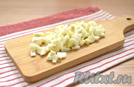 Нарезаем очищенные яйца на небольшие кусочки.