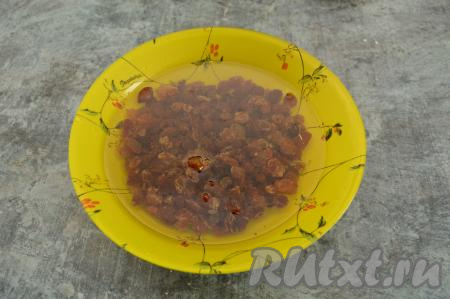 Первым делом следует подготовить изюм. Для этого залейте изюм кипятком и оставьте на 5 минут.