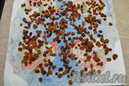 По прошествии 5 минут переложите изюм в сито, тщательно промойте под проточной водой, оставьте на несколько минут, чтобы стекла лишняя вода. А затем разложите изюм на плотной бумажной салфетке (или на бумажном полотенце), чтобы он немного обсох. Осмотрите изюм, если есть мелкие палочки, прикреплённые к изюминкам, удалите их.