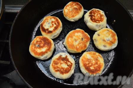 Жарить сырники с изюмом по 2-3 минуты с каждой стороны (до золотистой корочки) на среднем огне. Когда сырники уже поджарились и стали румяными с двух сторон, я обычно выключаю огонь, накрываю сковороду крышкой и даю сырникам потомиться ещё 5 минут, как бы "пропариться".