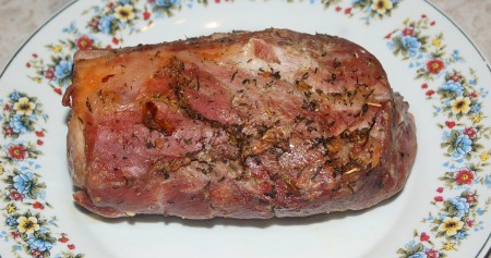 Переложить целый кусок запечённой свинины из рукава на блюдо.