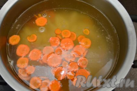 Когда рыбный бульон закипит, выложить в него морковку с картошкой, дать закипеть и варить на небольшом огне 10 минут.