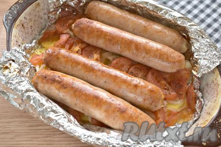 Отправляем форму с купатами и картошкой в духовку, прогретую до 200 градусов, на 30 минут, затем фольгу раскрываем и продолжаем запекать ещё 10-15 минут. Готовность блюда проверьте, проколов картошку вилкой, если кружочки картофеля стали достаточно мягкими, вилка входит в них легко, значит можно доставать форму из духовки.