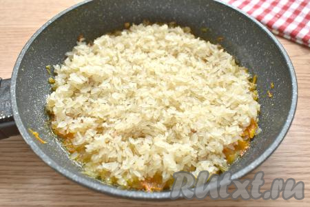 К тушёнке и овощам выкладываем ровным слоем подготовленный рис.