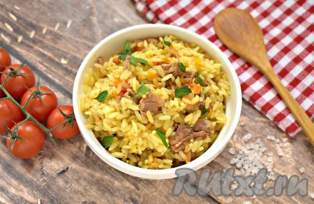 Плов, приготовленный с тушёнкой, получился сытным, аппетитным, рассыпчатым, раскладываем его со сковороды по тарелкам, по желанию, посыпаем нарезанной зеленью и подаём к столу. Приготовьте это блюдо и оно удачно впишется в повседневное меню!