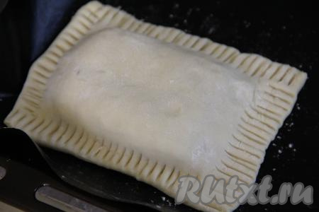 Выложить поверх "веера" из яблок один прямоугольник из слоёного теста и прижать края теста к коврику (или пергаменту) при помощи вилки.