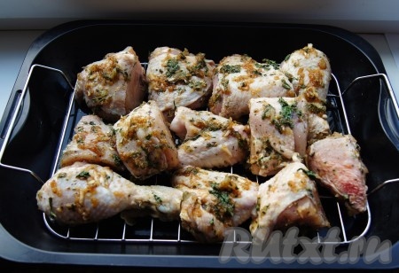 По прошествии времени выложить замаринованные кусочки курицы в жаропрочную форму, застеленную пергаментом (или смазанную маслом). В этот раз я решила разложить курочку на решётке с поддоном.