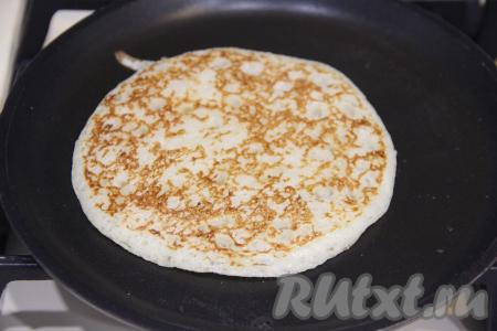 Жарить до золотистого цвета с другой стороны, а затем аппетитный, толстенький дрожжевой блин переложить на тарелку. Постепенно пожарить все блины. В процессе выпечки блинов тесто в миске перемешивать не нужно.