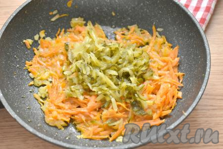 Солёный (или маринованный) огурец натираем на крупной тёрке, добавляем к морковке с луком, перемешиваем и обжариваем, иногда помешивая, в течение 3 минут.