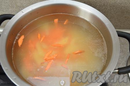 В закипевший бульон выложить морковь и картошку, снова дать закипеть, а затем варить минут 10 на небольшом огне.
