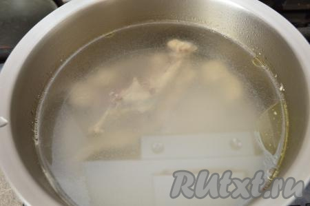 Части курицы вымыть, выложить в кастрюлю, залить 2-2,5 литрами воды и поставить на огонь. После закипания убрать пену, уменьшить огонь и варить куриное мясо минут 30. Затем вынуть мясо из бульона, дать ему немного остыть. Бульон процедить и вернуть в кастрюлю, поставить на огонь.