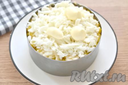 Куриные яйца разделяем на белки и желтки. Сейчас нам потребуются только белки. Натираем их на крупной тёрке, выкладываем поверх кукурузы, немного солим и смазываем майонезом.