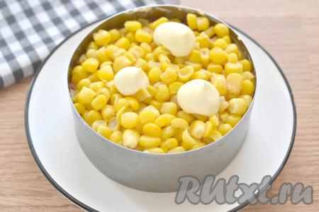 Консервированную кукурузу выкладываем вначале на сито, чтобы стекла лишняя жидкость. А затем раскладываем кукурузу равномерно поверх моркови, смазываем майонезом.