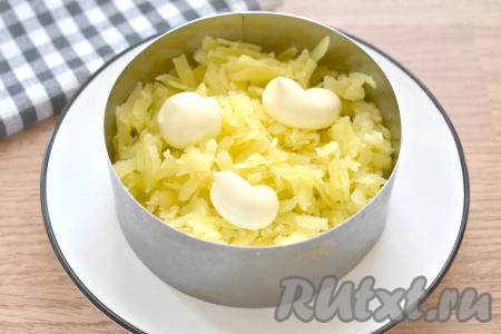 Прежде всего вымытые морковь и картофель, не очищая от кожуры, отварить до готовности (на варку картошки с момента закипания воды потребуется минут 20-25, моркови - минут 30-35, готовые овощи должны легко прокалываться вилкой). Дать моркови и картошке полностью остыть. Яйца сварить вкрутую (в течение минут 10 после закипания воды), остудить их и очистить. Я делала порционную подачу, поэтому формировала салат с помощью 2 сервировочных колец диаметром 11 сантиметров, но можно выкладывать слоями и в один подходящий по размеру салатник. Итак, приступаем к формированию слоёного салата. Картофель очищаем, натираем на крупной тёрке, выкладываем его равномерно первым слоем, немного подсаливаем, покрываем майонезом. Я выкладывала в 2 формочки, поэтому равномерно распределяла ингредиенты по двум формам.