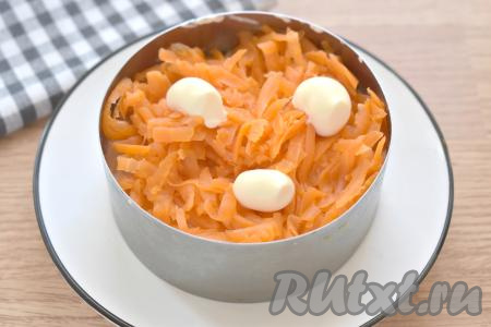 Очищенную варёную морковь натираем на крупной тёрке, выкладываем поверх рыбы, смазываем майонезом.