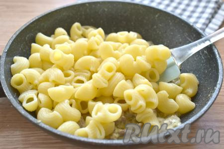 Готовые макароны откидываем на дуршлаг, даём стечь лишней воде. А затем перекладываем в сковороду к фаршу, протушившемуся в сливках.