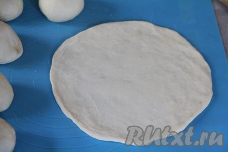 На присыпанной мукой поверхности раскатать каждый шарик в тонкую, круглую лепёшку диаметром примерно 18 сантиметров.