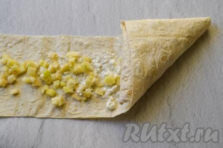 А затем продолжайте сворачивать лаваш с начинкой, каждый раз подворачивая его в виде треугольника.