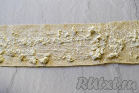 Разделите творожную массу на 4 равных части. Одну часть творожной массы разложите на первую полоску лаваша, немного отступив от краёв.