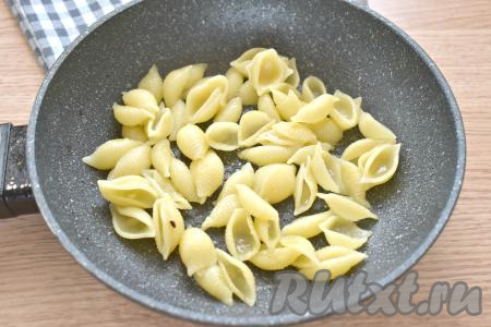 Когда макароны будут готовы, откидываем их на дуршлаг, чтобы вся вода полностью слилась. Разогреваем на сковороде растительное масло, выкладываем отваренные макароны и обжариваем их в течение 1-2 минут, периодически аккуратно перемешивая.