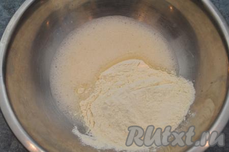 Всыпать в миску половину муки, перемешать столовой ложкой.