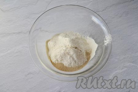 В глубокую миску просейте пшеничную муку, всыпьте сахар, соль и сухие дрожжи, перемешайте сухие ингредиенты.
