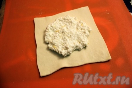 Каждый квадратик немного раскатайте, сохраняя его форму и выложите творожную начинку.