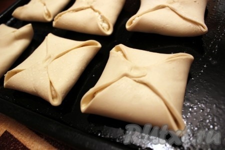 Соедините концы теста к центру "конвертиком" и закрепите их, выпекайте "венгерки" - слойки с творогом на смазанном растительным маслом и сбрызнутым водой противне в разогретой духовке при температуре 200 градусов около 15-20 минут.