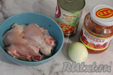 Подготовить продукты для приготовления курицы, тушёной с консервированной фасолью в томатном соусе. Лук и чеснок почистить. Порционные части курицы промыть, по желанию, можно снять кожу, затем посолить. Консервированную фасоль можно взять любую, я использовала белую консервированную фасоль в томатном соусе. Для этого рецепта можно использовать любые порционные части курицы. Я взяла ножки, бёдра и крылья.