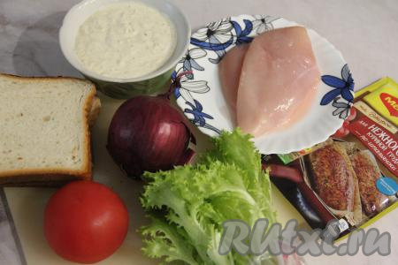 Подготовить продукты. Из указанного количества ингредиентов мы сделаем 2 клаб-сэндвича с курицей. Листья салата и помидор вымыть. Лук и чеснок очистить. Куриное филе промыть водой, обсушить. 