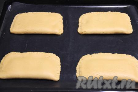 Скрепить руками края пряника при помощи защипов или придавить вилкой. Переложить заготовку тульского пряника на противень, застеленный ковриком (или пергаментом) для выпечки. Аналогично сформировать ещё 6 пряников и выложить их на подготовленный противень на расстоянии друг от друга.