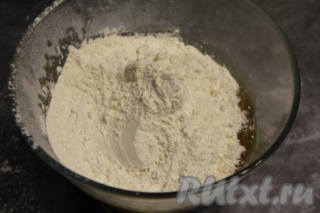 Всыпать часть муки, перемешать ложкой. Затем начать частями добавлять оставшуюся муку. Сначала перемешивать тесто для пряника ложкой, а когда тесто станет более твёрдым, продолжить замес руками.