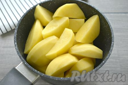 Очищаем картошку, крупные клубни разрезаем на части (я нарезала на крупные ломтики), перекладываем в кастрюлю. Полностью заливаем картофель холодной водой, доводим на сильном огне до кипения. А затем варим до готовности (мне потребовалось 25 минут) на небольшом огне. Убираем с огня, весь картофельный отвар из кастрюли сливаем.