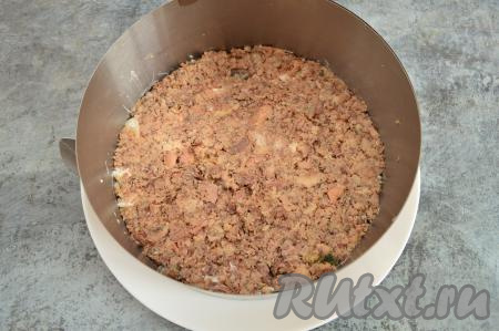 Рыбные консервы открыть, слить лишнее масло. Рыбу из консервов переложить на тарелку, удаляя крупные кости, затем размять вилкой. Выложить размятую рыбку ровным слоем поверх риса, слегка прижать.