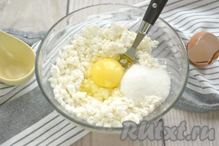 К творогу разбиваем куриное яйцо и всыпаем сахар (количество сахара - на ваше усмотрение, можно добавить чуть меньше или больше). Если хотите сладкие сырники - тогда добавьте 2-3 столовых ложки сахара. Я добавила 1 столовую ложку сахара и сырники получились в меру сладкими.