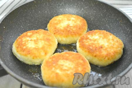 Вливаем на сковороду примерно 2 столовых ложки растительного масла. Хорошо разогреваем масло и выкладываем на сковороду заготовки сырников в панировочных сухарях. На среднем огне жарим сырники примерно по 3-3,5 минуты с каждой стороны (до подрумянивания).