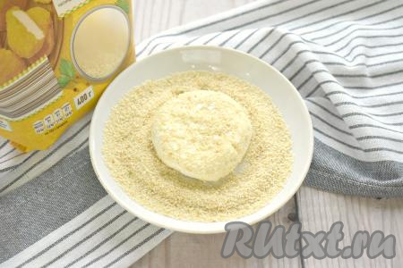 Высыпаем на тарелку панировочные сухари, каждый колобок из творожного теста опускаем в панировочную смесь и немного прижимаем сверху колобок рукой. Обваливаем сырники в сухарях с каждой стороны и по бокам.