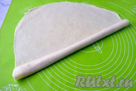 Отдохнувшее тесто будет очень податливым и удобным в работе. Оно легко раскатывается, не рвётся и не прилипает к скалке. Раскатайте один шар теста на припылённой мукой поверхности в тонкий пласт. Смажьте пласт 1 чайной ложкой растительного масла и скрутите в плотный рулет.