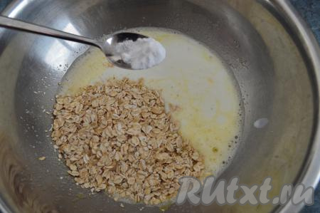 В миску с яичной смесью влить кефир комнатной температуры, всыпать овсяные хлопья и соду. Кефир очень удобно подогревать до комнатной температуры в микроволновке, я ставлю в микроволновку на максимальную мощность на 30 секунд.